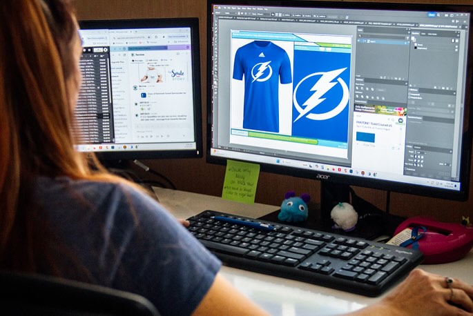 A Brandhouse designer previewing a custom jersey design on screen